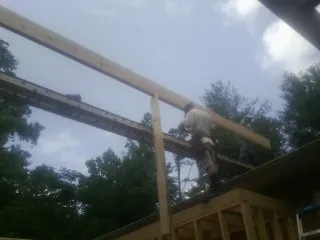 Carpenter setting a ridge beam over a new addition frame — Ice Dam Removal by Roofing Brothers in Rhodhiss