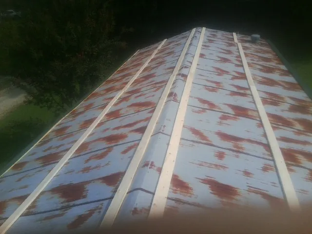 Rusted metal roof panels with new wood purlins before replacement — Storm Damage Roof Repair in Rhodhiss by Roofing Brothers