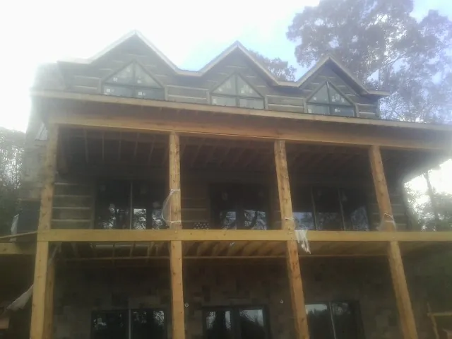 Dormers and porch framing on a large log home under construction — Roof Coating work by our crew in Rhodhiss