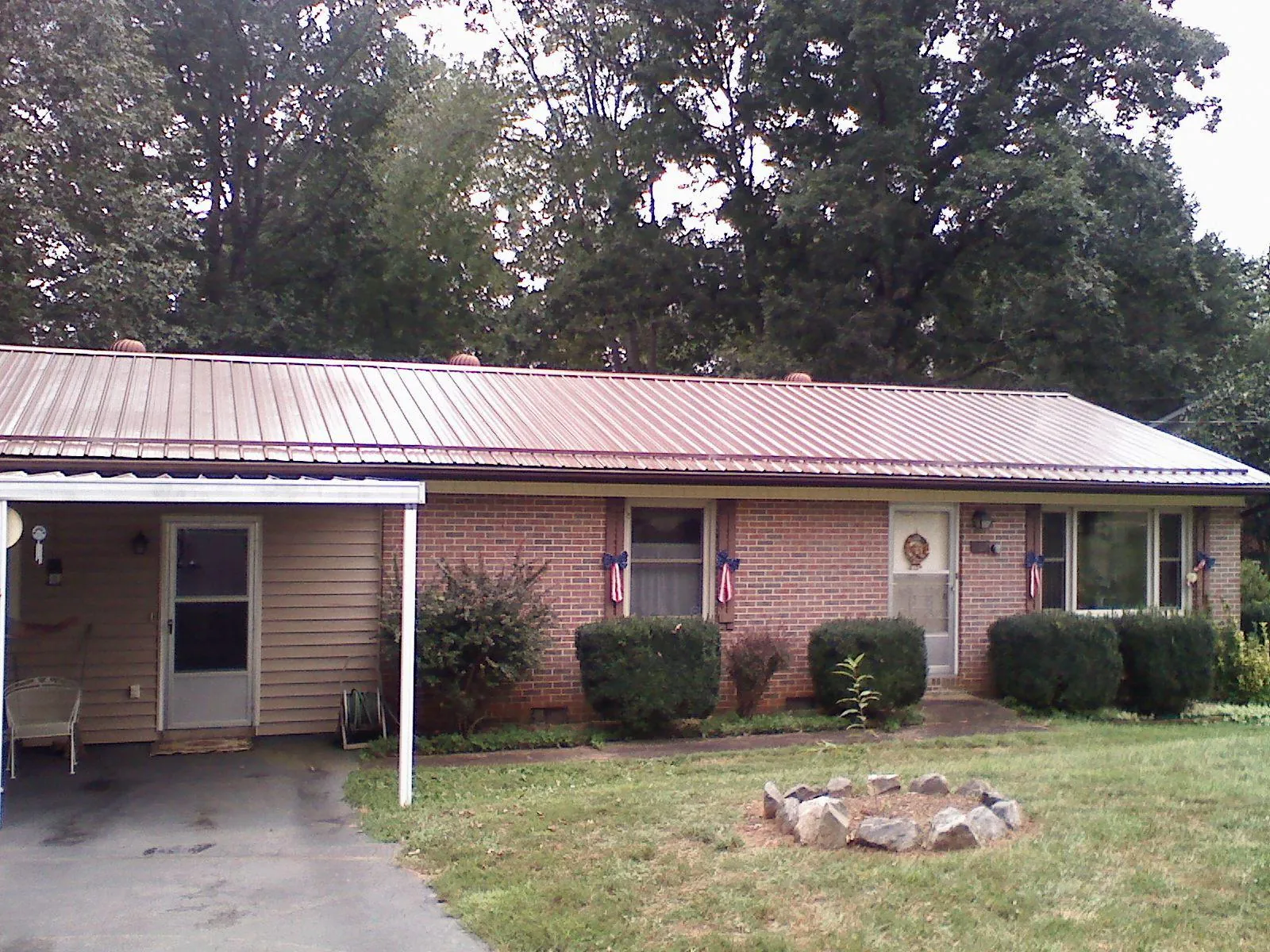 Bronze metal roof and carport on a brick ranch home — Roof Repair work by our crew in Rhodhiss